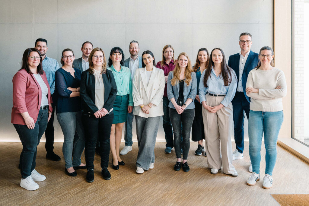 Das Team von Stiefvater & Walk steht gemeinsam in lockerer Atmosphäre für ein Gruppenfoto